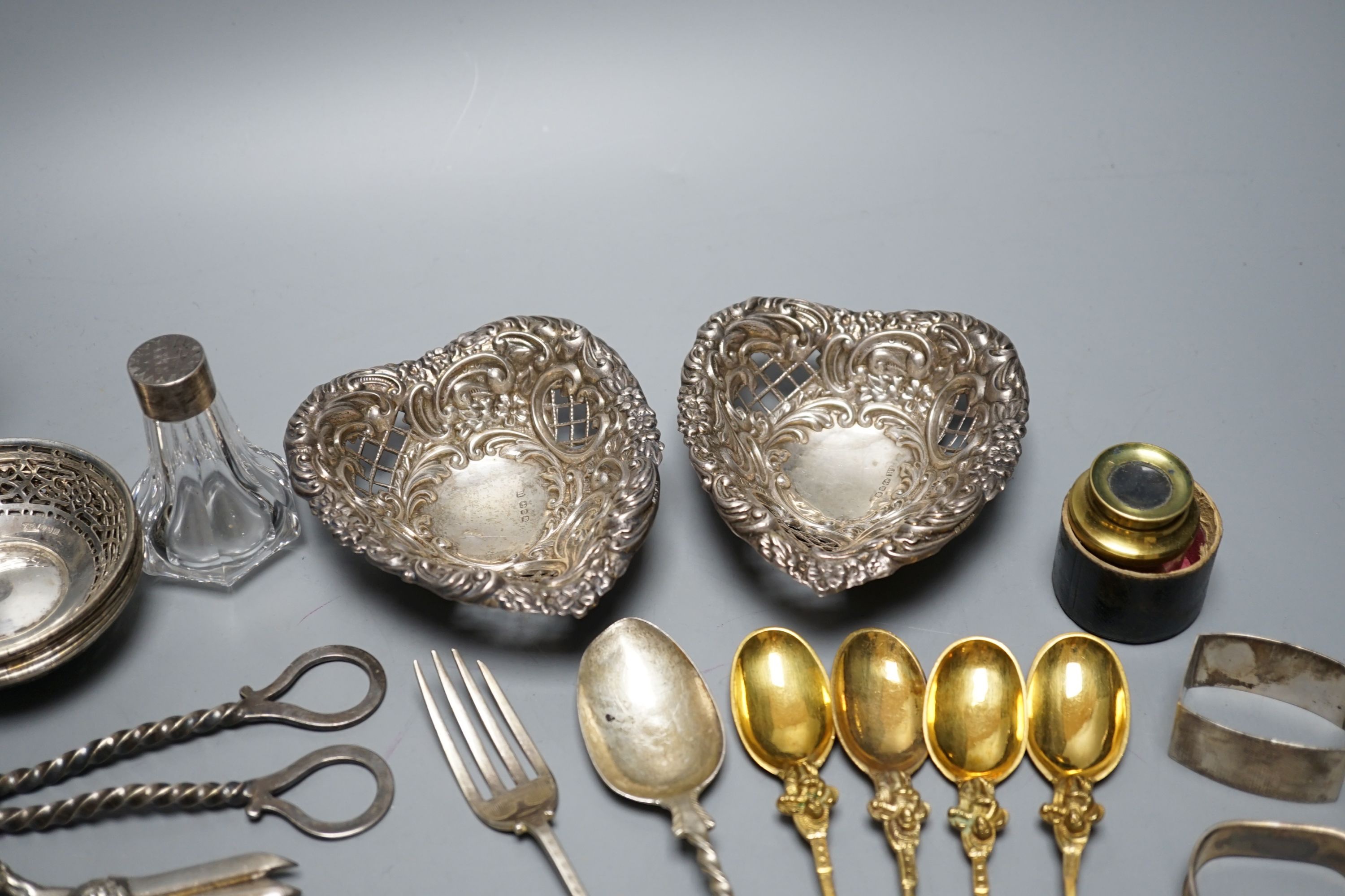 A cased Victorian silver part communion set, a silver cigarette case, two silver napkin rings, a set of five pierced silver bonbon dishes, a pair of Victorian silver grape shears, Georgian silver vinaigrette, pair of sil